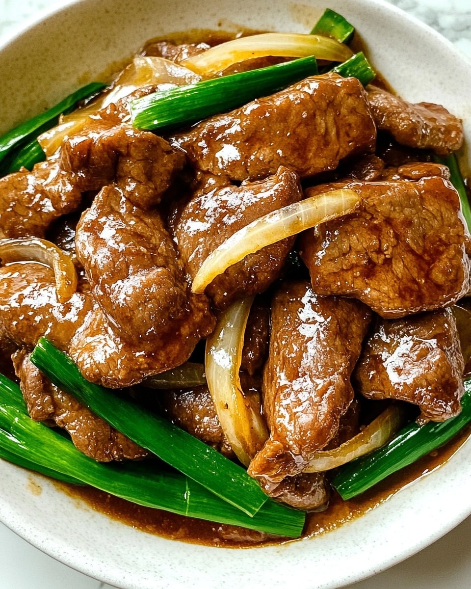 A white plate holds two layers: the bottom layer is a mound of white rice with a soft, fluffy texture, taking up half the plate on the right side. On the left side and slightly over the rice, thin slices of brown beef are spread on top, covered in a shiny dark brown sauce. Mixed in with the beef are long strips of lightly cooked onions, pale yellow and slightly translucent, and green beans adding a fresh green color. The dish sits on a white marbled surface with light chopsticks placed near the plate and a small wooden bowl with green herbs in the background. photo taken with an iphone --ar 4:5 --v 6.1