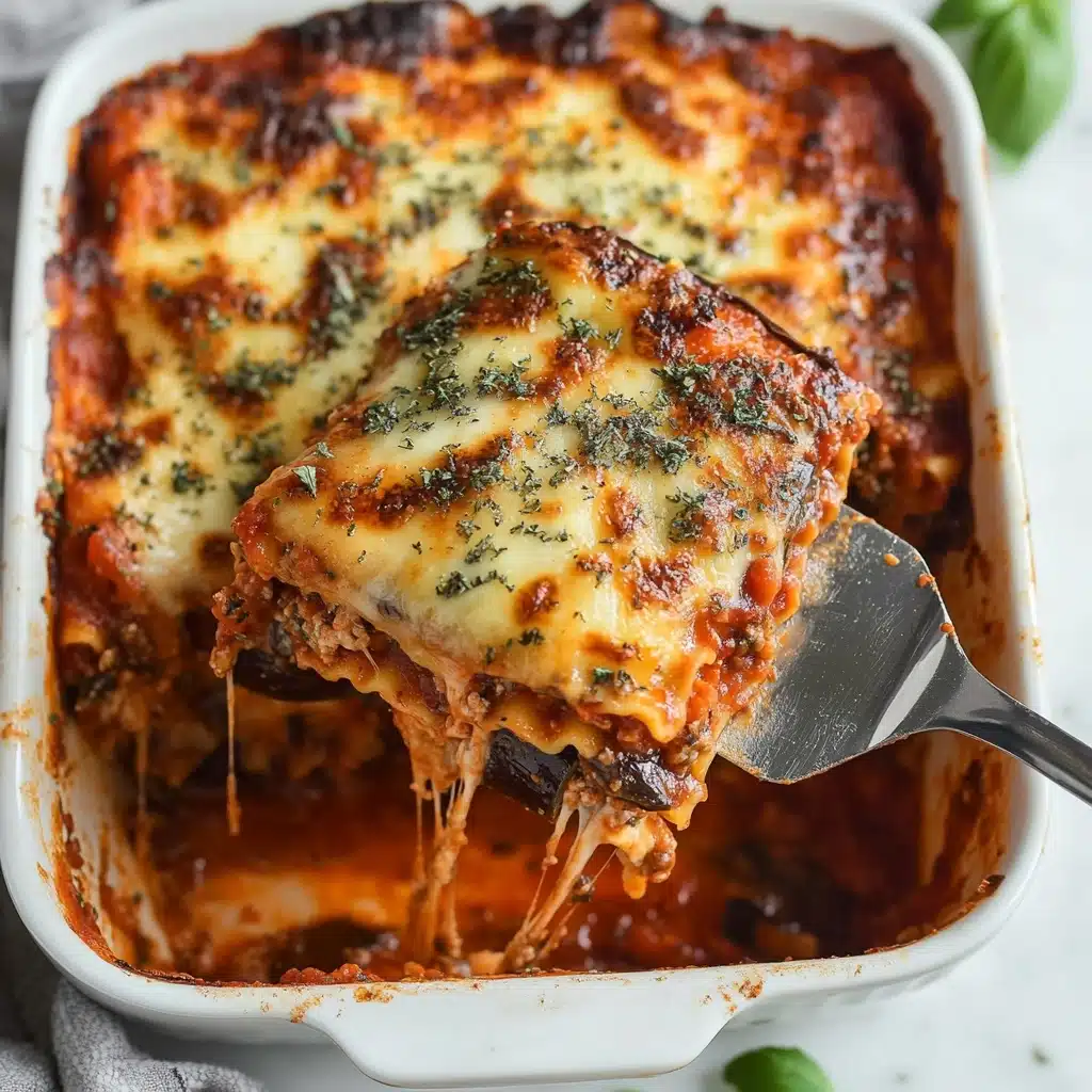 Provençal Eggplant Tomato Gratin, Mediterranean vegetable casserole, eggplant and tomato bake, hearty eggplant gratin, flavorful vegetable gratin A white baking dish filled with a baked lasagna, showing three visible layers: the top layer is golden-brown melted cheese covered with dried green herbs, the middle layer has a red tomato sauce with bits of herbs and some eggplant pieces, and the bottom layer appears to be pasta with sauce. A stainless steel spatula holds a square piece lifted from the dish, with cheese strings slightly stretching from the lasagna in the dish. The dish sits on a white marbled surface with a small green basil leaf nearby.