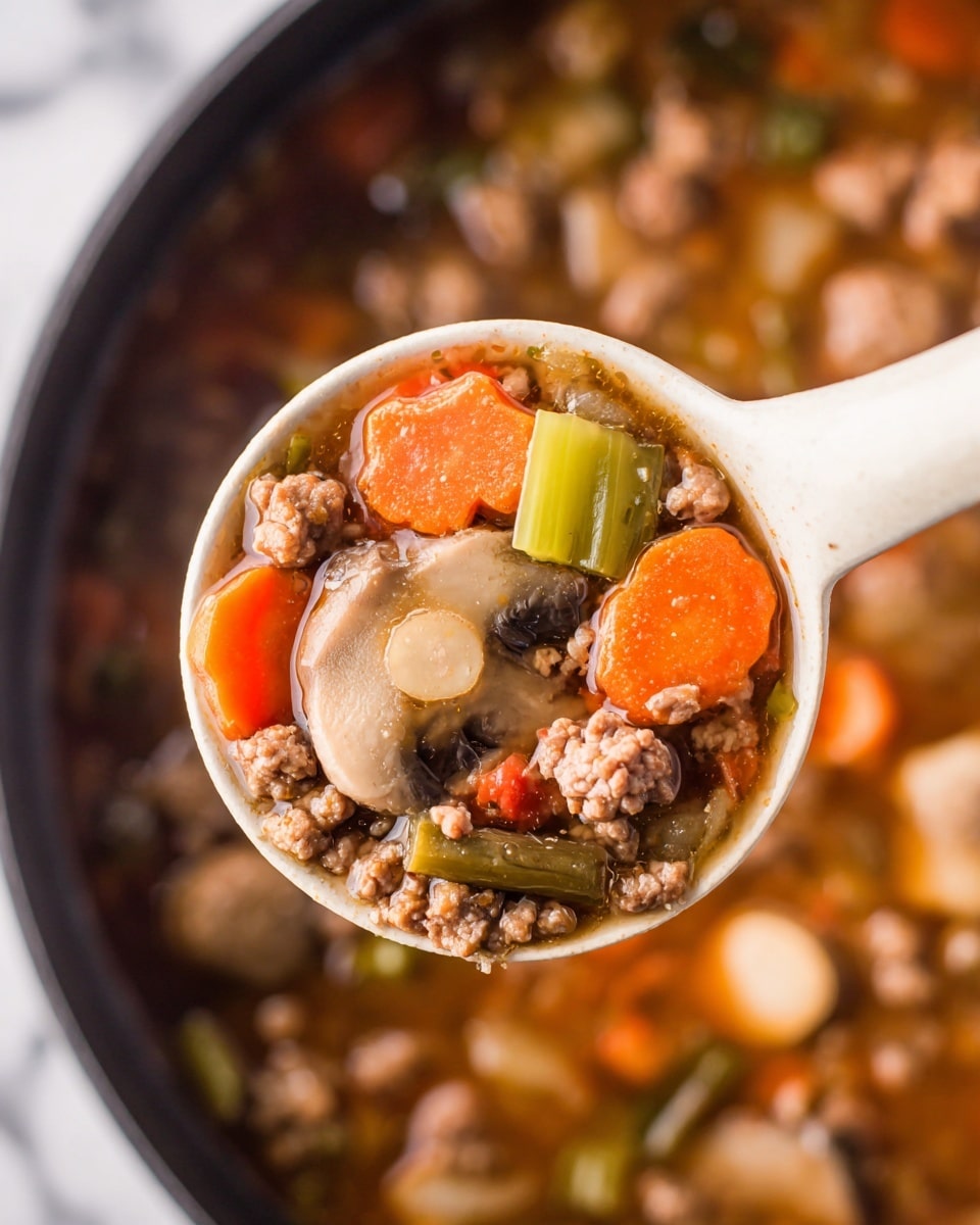 The image shows a white bowl filled with a hearty soup made of several visible layers and ingredients. The bottom layer is a rich, brown broth with a slight oily shine on the surface. Floating in the soup are chunky pieces of light yellow potato slices, bright orange carrot slices, small whole brown mushrooms, and pieces of cooked ground meat with a crumbly texture. There are also visible green celery slices and small bits of red tomato. The bowl is placed on a wooden surface next to a silver spoon, a white marbled texture surface is around it, and a part of a black slow cooker dial and a red-striped cloth are visible near the top. Photo taken with an iphone --ar 4:5 --v 7