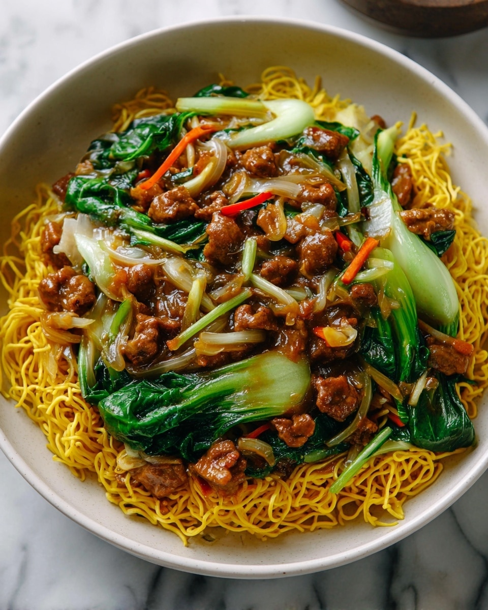 A large white speckled bowl filled with three main layers: the bottom layer has thin, yellow, slightly crispy noodles spread evenly; the middle layer consists of dark brown cooked beef pieces mixed with bright green cooked bok choy and thin strips of orange carrots and translucent cooked onions; the top layer shows some noodles being lifted by a pair of wooden chopsticks, highlighting the shiny, saucy texture of the beef and vegetables mixed with the noodles. The bowl sits on a white marbled surface. Photo taken with an iphone --ar 4:5 --v 7