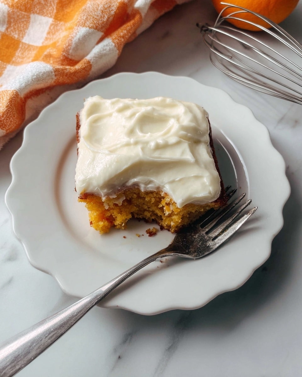 A single piece of orange-brown cake with one visible layer topped with a thick, creamy white frosting spread unevenly on top, placed on a white plate with a scalloped edge. A metal fork lies on the plate next to the cake, with the cake showing a bite taken from one side. The scene is set on a white marbled surface with part of an orange and white checkered cloth and a metal whisk partially visible in the background. Photo taken with an iphone --ar 4:5 --v 7