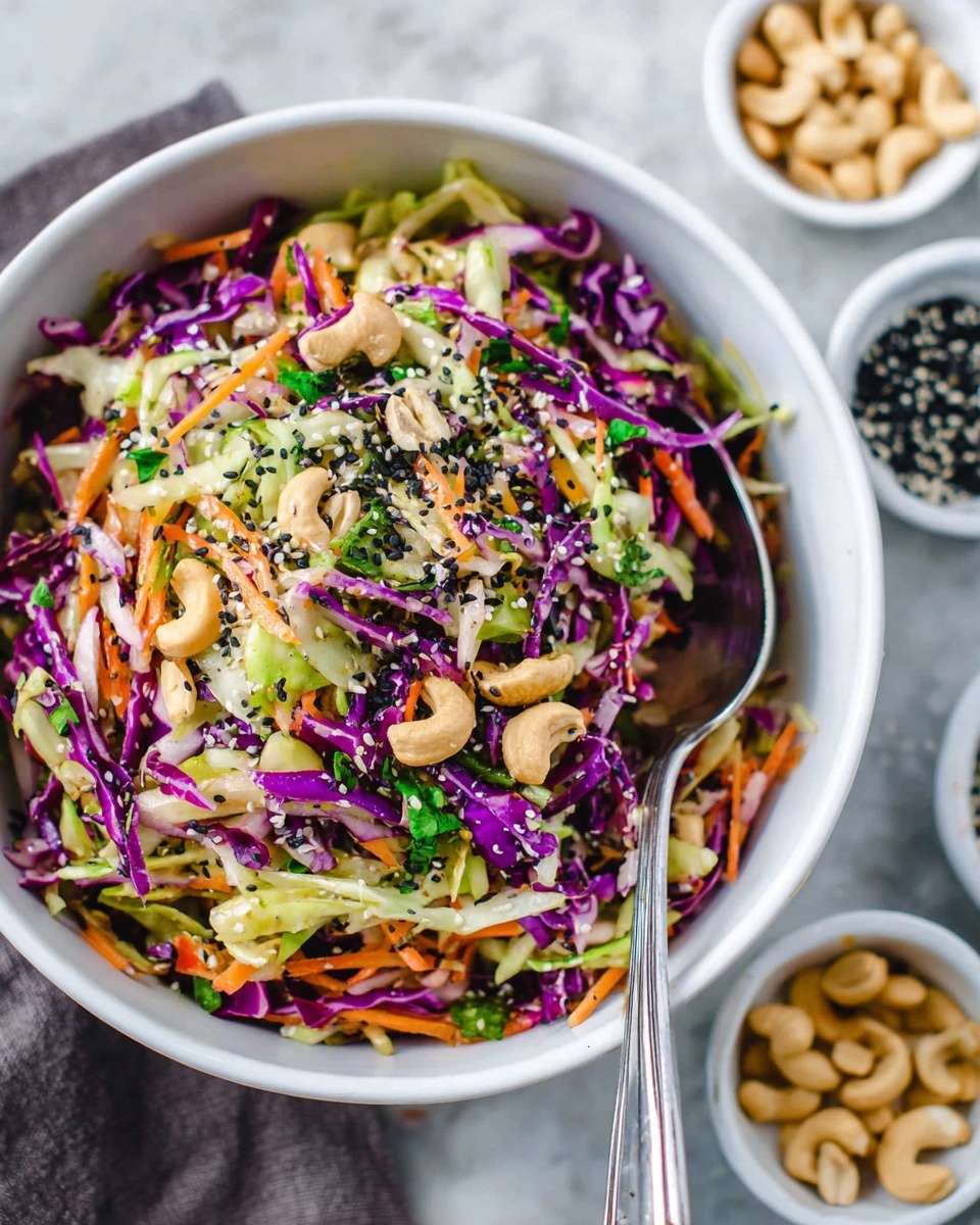 A white bowl filled with a colorful shredded salad sits on a white marbled surface. The salad has many thin layers: purple cabbage strips, light green cabbage pieces, and orange carrot shreds, mixed with fresh green herbs. Scattered on top are pale cashew nuts and small black sesame seeds, adding texture. Two silver forks rest inside the bowl on one side. Around the bowl, small white bowls hold cashews, chopped greens, and black sesame seeds, with some nuts and herbs scattered on the surface. photo taken with an iphone --ar 4:5 --v 7