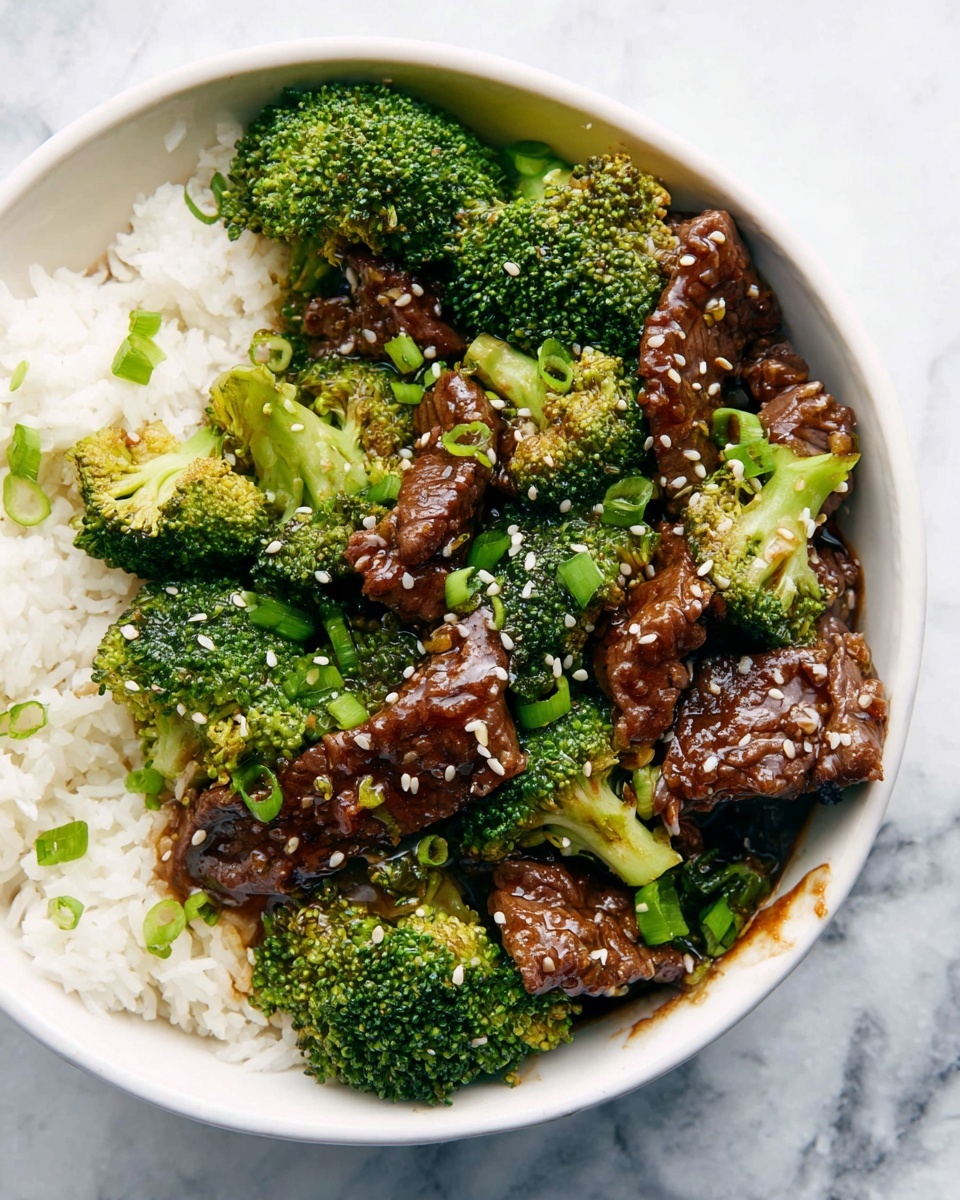 A white bowl filled with three main layers: at the bottom there is a layer of white rice on one side, the middle layer has bright green broccoli florets spread evenly throughout, and the top layer displays dark brown cooked beef slices coated in a shiny sauce, sprinkled with light tan sesame seeds and small pieces of chopped green onions. The broccoli and beef sit together, covering most of the rice, with some sauce visible around the edges on a white marbled table. Photo taken with an iphone --ar 4:5 --v 7