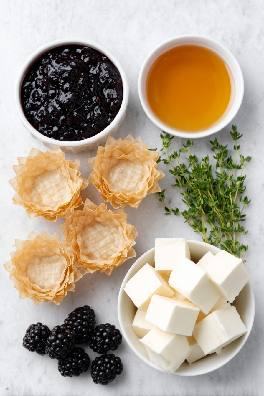 Flat lay of fresh golden mini phyllo shells arranged neatly, a small white ceramic bowl with glossy deep purple blackberry jam, another small white bowl filled with clear golden honey, creamy pale off-white cubes of brie cheese without rind, a handful of plump fresh blackberries with a rich dark purple hue, and a few sprigs of vibrant green fresh thyme artfully placed, all ingredients balanced symmetrically and naturally placed on a clean white marble surface, soft natural light, photo taken with an iPhone, professional food photography style, fresh ingredients, white ceramic bowls, no bottles, no duplicates, no utensils, no packaging --ar 2:3 --v 7 --p m7354615311229779997 - Brie and Blackberry Phyllo Cups, elegant appetizer recipes, easy party appetizers, quick finger food ideas, sophisticated small bites