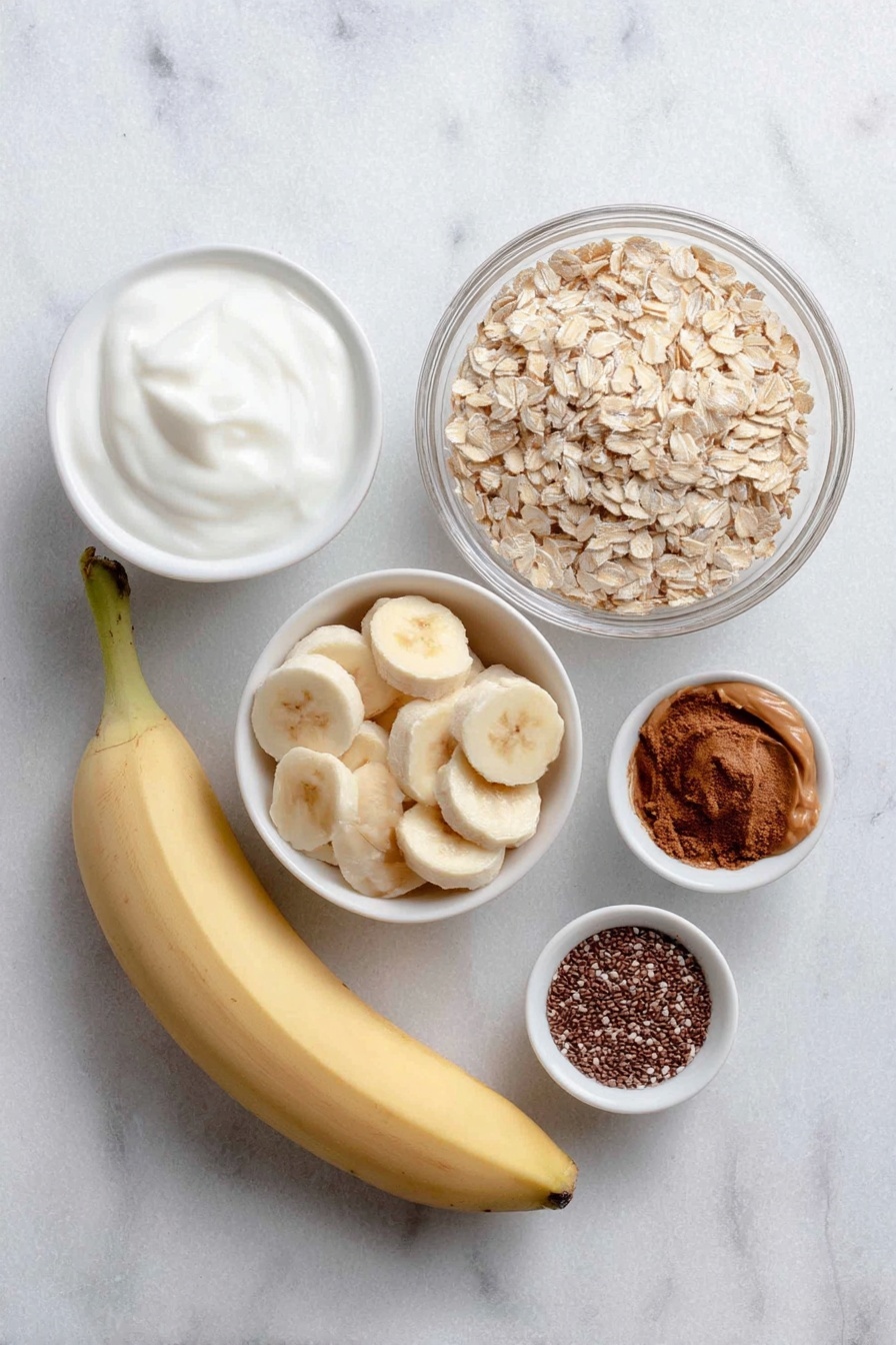 Flat lay of a large ripe banana, several fresh banana slices arranged neatly, a small white bowl of creamy vanilla yogurt, a small white bowl of rolled gluten-free oats, a small white bowl of smooth peanut butter, a small white bowl of almond milk, a small white bowl of chia seeds, a small white bowl of ground cinnamon, placed on a clean white marble surface, soft natural light, photo taken with an iPhone, professional food photography style, fresh ingredients, white ceramic bowls, no bottles, no duplicates, no utensils, no packaging --ar 2:3 --v 7 --p m7354615311229779997 - High Protein Peanut Butter Banana Overnight Oats, healthy overnight oats, high protein breakfast, easy breakfast recipes, nutritious oat bowls