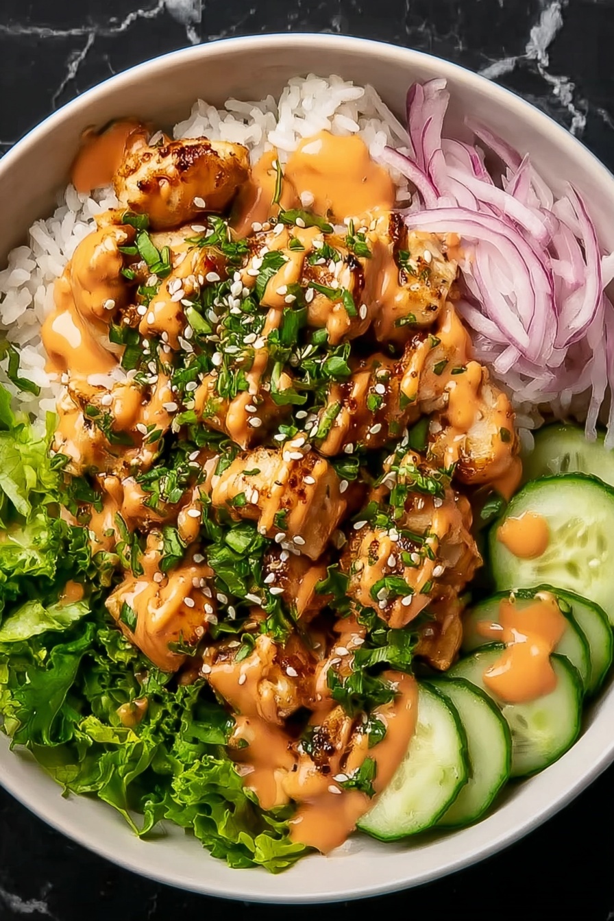 A bowl with a base layer of white rice topped with chopped green lettuce and thinly sliced red onions on one side. Small, golden-brown grilled chicken pieces are placed in the center, covered with green chopped herbs and white sesame seeds. On the right side, there are thin, round cucumber slices. The dish is drizzled with an orange creamy sauce over the chicken and cucumbers. The bowl is white and set on a white marbled surface. Photo taken with an iphone --ar 2:3 --v 7 - Bang Bang Chicken Rice Bowl, easy Asian chicken bowls, quick dinner recipes, flavorful chicken rice bowl, spicy mayo chicken bowl