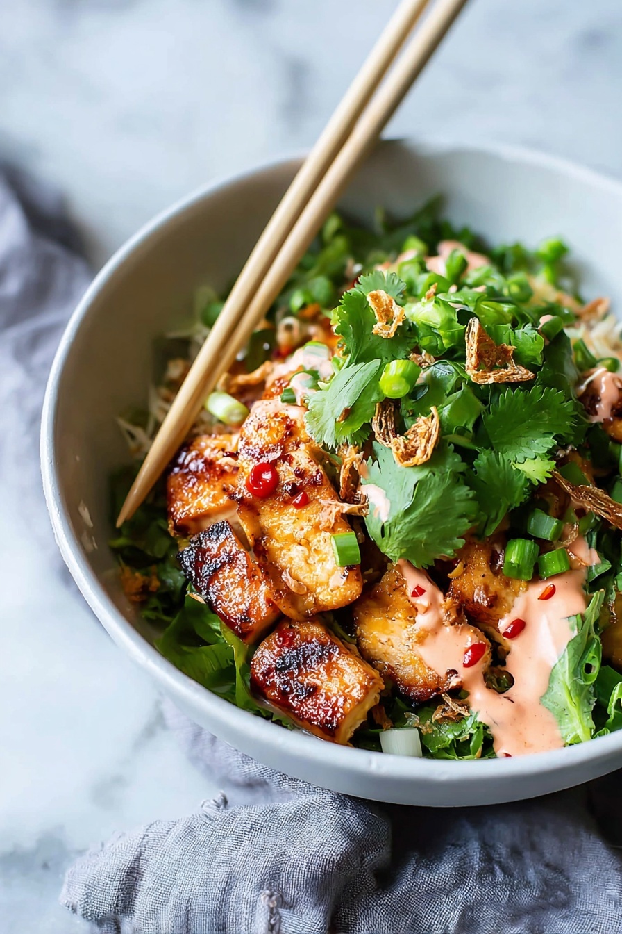 A white bowl holds a colorful dish with several layers starting with golden-brown grilled chicken pieces that have a shiny glaze with small red chili spots, placed at the bottom. On top there is a generous layer of fresh, bright green cilantro leaves and chopped green onions, adding a fresh texture. Some crispy fried shallots are scattered over the greens, and drizzled in spots is a light pink creamy sauce. A pair of light wood chopsticks rest on the rim of the bowl, angled over the food. The bowl sits on a white marbled surface with a soft gray cloth partly visible beside it. Photo taken with an iphone --ar 2:3 --v 7 - Sticky Glazed Tofu Bowl with Yum Yum Sauce, tofu bowl recipe, vegetarian Asian bowl, quick tofu dinner, flavorful tofu dishes
