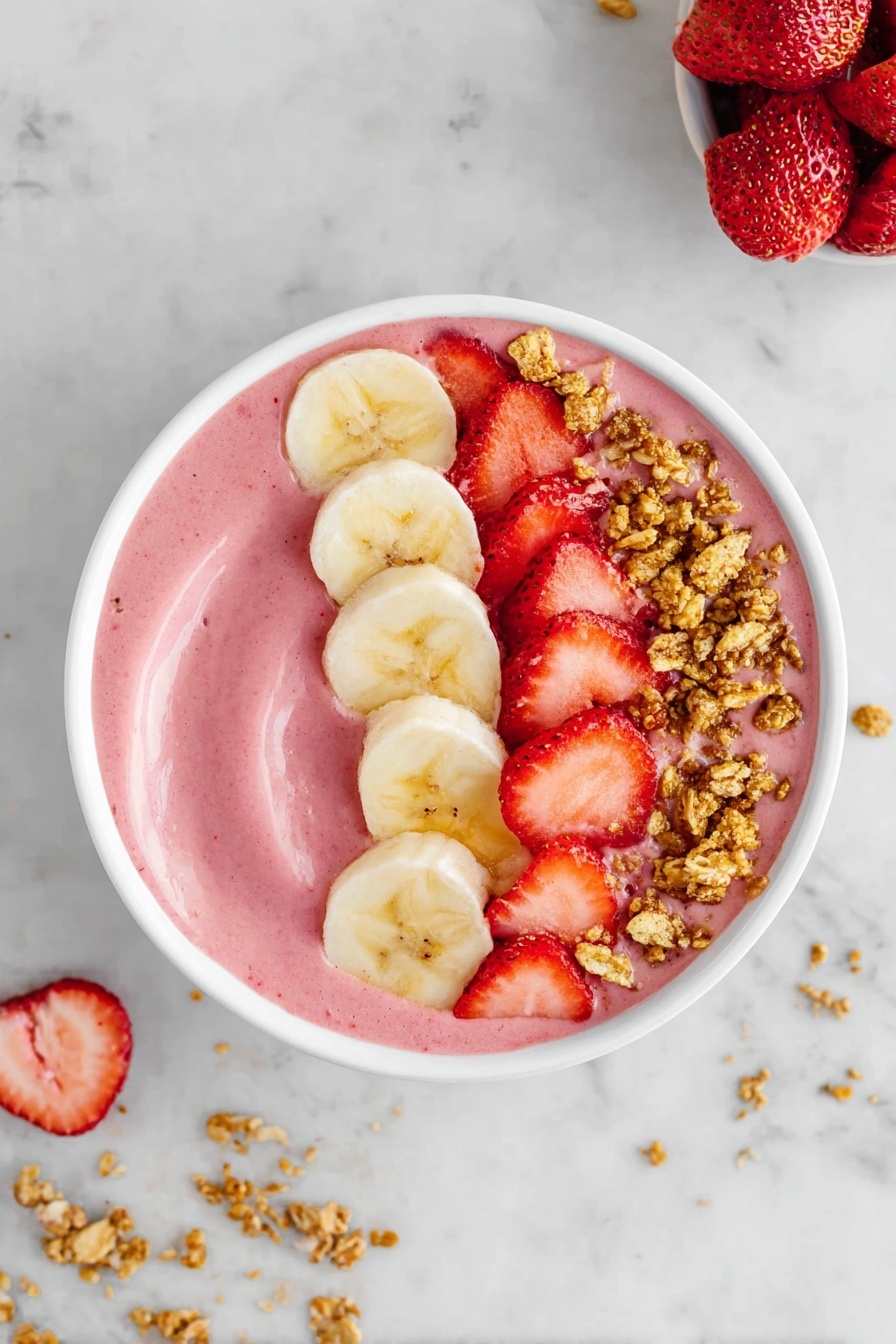 The image shows a white bowl filled with a smooth pink smoothie base. On top, there are three distinct layers arranged in a half-circle: a row of light yellow banana slices on the right, a line of bright red chopped strawberries next to the bananas, and small clusters of golden brown granola scattered over the strawberries. The bowl sits on a white marbled surface with small bits of granola scattered around. Photo taken with an iphone --ar 2:3 --v 7 - Strawberry Banana Smoothie Bowl, healthy smoothie bowl recipes, easy breakfast ideas, fruit smoothie bowl, quick nutritious snacks