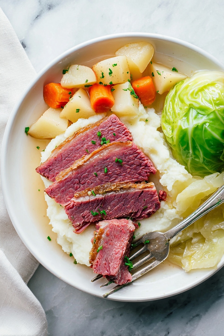 A white plate sits on a white marbled surface holding three thick slices of pink corned beef with a brown edge placed on a bed of smooth white mashed potatoes. To the left of the beef are small chunks of soft-looking orange carrots and light yellow potatoes mixed with pearl onions. To the right side of the plate, a portion of cooked green cabbage leaves is neatly folded. A silver fork rests diagonally on the mashed potatoes with one piece of beef pierced on its prongs and a touch of green garnish scattered lightly over the entire dish. photo taken with an iphone --ar 2:3 --v 7 - Slow Cooker Corned Beef and Cabbage, corned beef and cabbage dinner, easy slow cooker corned beef, Irish corned beef recipe, St. Patrick's Day corned beef