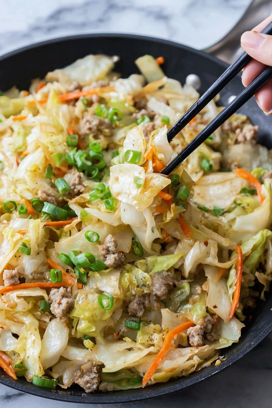 In a black pan, there is a mix of cooked cabbage pieces that are pale yellow with a soft texture, thin orange carrot strips scattered throughout, and small light brown cooked meat bits. On top, bright green chopped scallions add freshness. A woman's hand holds black chopsticks lifting a portion showing these layers clearly. The food looks slightly shiny as if lightly cooked with seasoning. The background surface is white marbled texture. photo taken with an iphone --ar 2:3 --v 7 - Egg Roll in a Bowl, healthy egg roll stir-fry, quick Asian ground turkey skillet, low-carb egg roll bowl, easy weeknight dinner